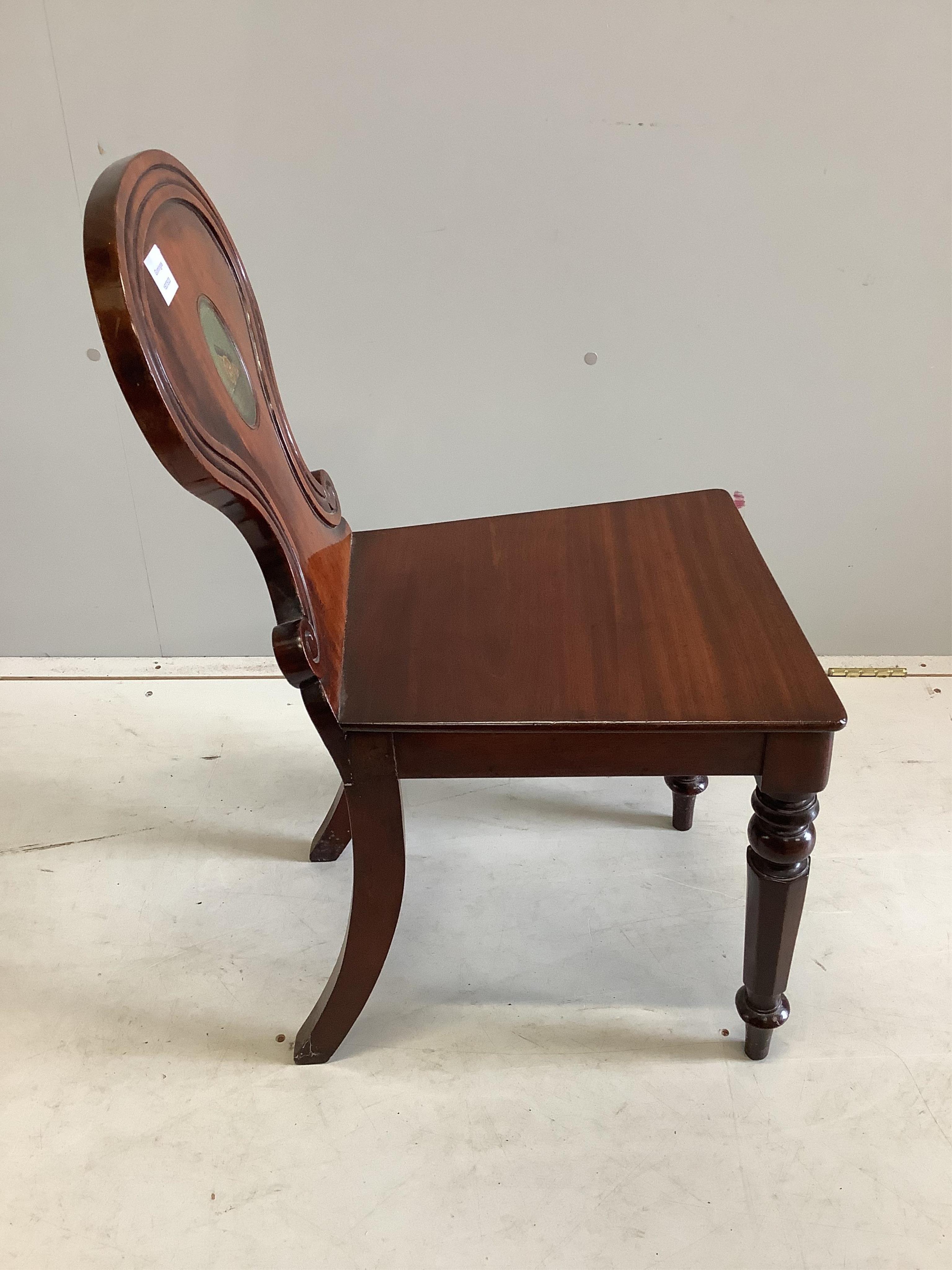 An early Victorian mahogany hall chair with painted armorial, width 38cm, depth 45cm, height 79cm. Condition - fair